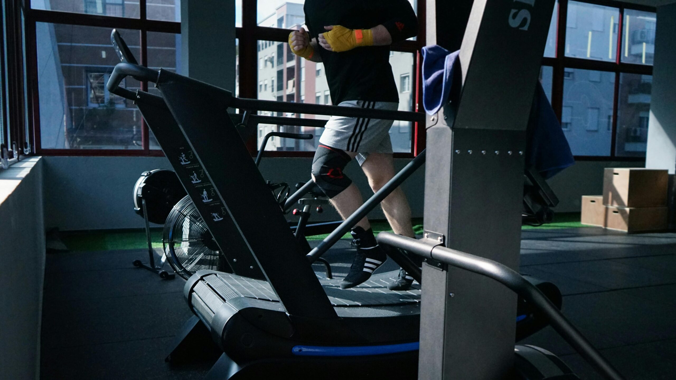 Erwachsener Mann trainiert auf einem Laufband in einem modernen Fitnessstudio.